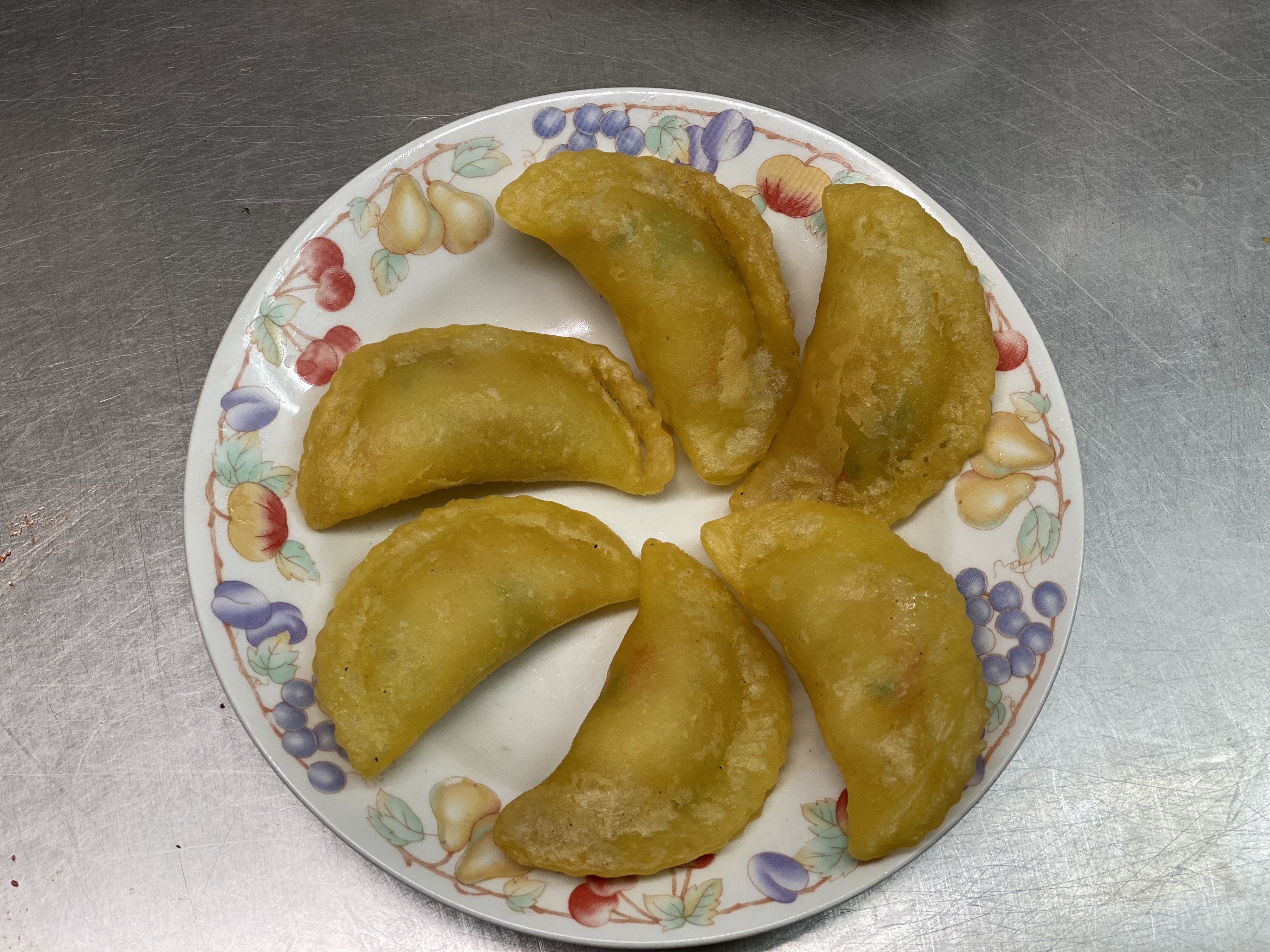 Crispy brown dumplings lay on a white plate.